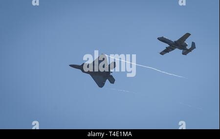 Eine F-22 Raptor der 94th Fighter Squadron bei Joint Base Langley - Eustis, Virginia zugewiesen und ein A-10 Warthog auf der 75th Fighter Squadron bei Moody Air Force Base, Ga, fliegen über Columbus AFB, Florida, März 27, 2019 zugeordnet. Piloten von Air Combat Command und Air Force Special Operations Team besucht BLAZE Fähigkeiten und ihrer Flugzeuge beantworten Fragen über das Berufsfeld zu erklären. Stockfoto