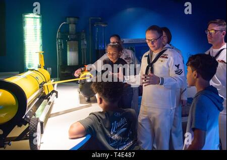 MIAMI (28. März 2019) Aerographer Mate 2. Klasse Jakob Gradert, an die Marineschule Ozeanographie Office zugewiesen wird, erzieht die Kinder über Marine Ozeanographie Segelflugzeuge während Miami Marine Woche im Phillip und Patricia Frost Museum der Wissenschaft. Miami Marine Woche, März 25-31, ist eine Reihe von Veranstaltungen im Miami Bereich Amerikaner verbinden mit der Marine. Es ist eine der 14 Marine Wochen von der Marine Büro für Öffentlichkeitsarbeit im Jahr 2019 organisiert, und zum ersten Mal in Miami eine Marine Woche bewirtet hat. Stockfoto