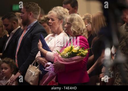 Der Kommandant der US Special Operations Command, US-Armee General Raymond A. Thomas III, geht in den Ruhestand Nach fast vier Jahrzehnten der Militärdienst, Tampa, Florida, 29. März 2019. Seine Frau, Barb Thomas, hält die Flagge, die er ihr in seinem Ruhestand überreicht wird, während Hollyanne Milley, die Frau von Generalstabschef Gen. Mark A. Milley, die Blumen hält. Stockfoto