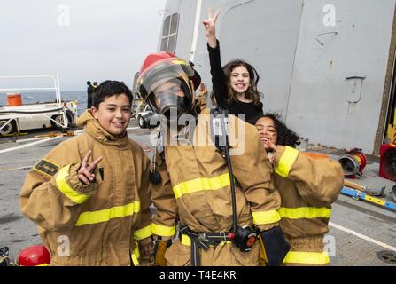 Philippinischen MEER (28. März 2019) Tiger posieren für ein Foto während damage control Training als Teil eines Tiger Kreuzfahrt an Bord des amphibious Transport dock Schiff USS Green Bay LPD (20). Tiger Kreuzfahrten sind eine Chance für die Gäste ein US-Schiff der Marine zu reiten und zu erfahren, was das Leben ist wie für die US-Navy Matrosen auf See. Green Bay, Teil der Wasp Amphibious Ready-Gruppe, die in der Region die Interoperabilität mit Partnern zu verbessern und dienen als eine tödliche bereit - Response Force für jede Art von Kontingenz. Stockfoto