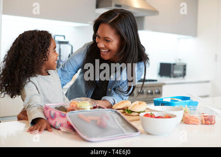 Tochter in der Küche zu Hause helfen Mutter gesund Lunchpaket zu machen Stockfoto