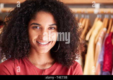 Portrait der weiblichen Kunden oder Eigentümer von Racks von Kleidung in Independent Fashion Store Stockfoto