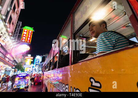 BANGKOK, THAILAND - MÄRZ 2019: Mann, der in den öffentlichen Bus durch China Town Night Market. Stockfoto