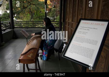 Vivian Zhu spielt eine traditionelle Guzheng am LAN-Su Chinesischer Garten in Portland. Stockfoto