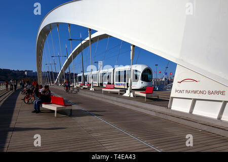 Menschen, Radfahrer, Fußgänger und eine Straßenbahn von Lyon auf der Fußgänger- und Fahrradbrücke Pont Raymond Barre über den Fluss Rhône Stockfoto