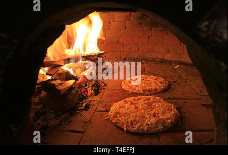 Pizza mit Käse und Tomaten im Holzofen gebackene Stockfoto