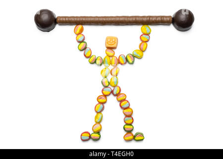 Süße Vorteile Konzept, isoliert. Kleiner Mann von Candy mit Candy Bar. Süßigkeiten geben Kraft und Freude. Kohlenhydrate die Hauptquelle der Energ Stockfoto