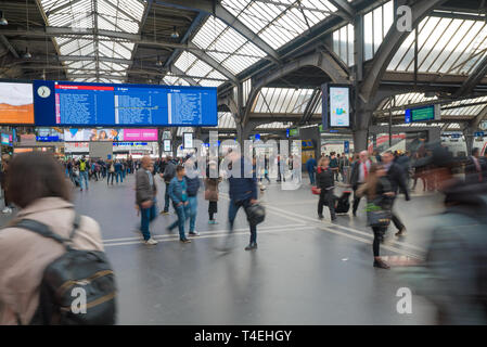 Zürich, ZH/Schweiz - April 8, 2019: Der Bahnhof Zürich und Züge mit Pendler und Leute zu ihren Zügen Eilt Stockfoto