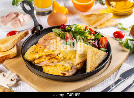 Omelette mit Schinken und Käse in eine Bratpfanne Stockfoto