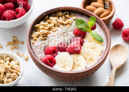 Acai Superfood Smoothie Schüssel mit Belägen wie Banane, Scheiben, frisch Himbeeren, Chia Samen und Müsli. Detailansicht. Konzept der sauber essen, di Stockfoto