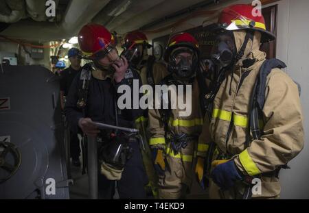 NEWPORT NEWS, Virginia (27. März 2019) Schäden Controlman 2. Klasse Brandon Carric, von Palm Springs, Kalifornien, zu USS Gerald R. Ford's (CVN 78) Engineering Abteilung zugewiesen sind, verwendet ein Radio Informationen bei einer Beschädigung des Bohrers zum Relais. Ford wird derzeit in post-shakedown Verfügbarkeit Huntington Ingalls Industries-Newport Nachrichten Schiffbau. Stockfoto