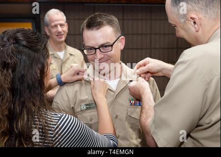 Marine Medizin West (NMW) Command Master Chief Loren Rucker und Frau Nicole Taylor pin First Class Insignia auf Hospital Corpsman 1. Klasse (HM1) David Taylor, nachdem er aus HM2 fortgeschritten war. Hintere Adm. Paul Pearigen, NMW Commander und Leiter des Medical Corps der Navy, Verdienstvoller advanced HM1 Taylor während einer alle Hände Anruf auf regionaler Hauptsitz onboard Naval Base San Diego. Die verdienstvolle Advancement Program enthält Befehle, die die Gelegenheit, ihre besten Segler zu erkennen, sie voran, wenn sie für die nächste Stufe der Verantwortung bereit sind. NMW führt der Marine Medizin westlichen Pazifik h Stockfoto