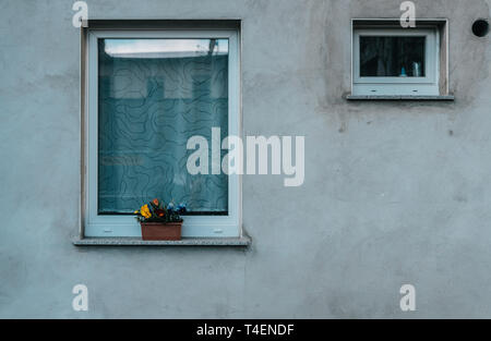 Schmutzig grauen Fassade mit großen und kleinen Fenster Stockfoto