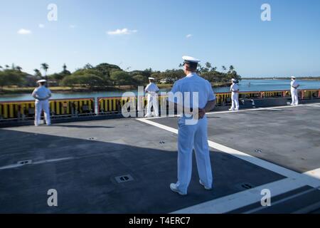 PEARL Harbor, Hawaii (Apr. 2, 2019) Matrosen an Bord geführte Anti-raketen-Zerstörer USS Zumwalt (DDG 1000) Mann der Schiene als das Schiff zieht in Pearl Harbor. Zumwalt leitet den Hafen besuchen Sie als Teil ihrer Routinetätigkeiten im östlichen Pazifik. Zumwalt Klasse Zerstörer bieten die Marine mit agilen militärische Vorteile im Meer und mit Bodentruppen an Land. Stockfoto