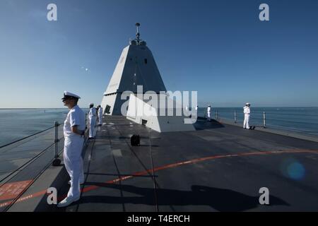 PEARL Harbor, Hawaii (Apr. 2, 2019) Matrosen an Bord geführte Anti-raketen-Zerstörer USS Zumwalt (DDG 1000) Mann der Schiene als das Schiff zieht in Pearl Harbor. Zumwalt leitet den Hafen besuchen Sie als Teil ihrer Routinetätigkeiten im östlichen Pazifik. Zumwalt Klasse Zerstörer bieten die Marine mit agilen militärische Vorteile im Meer und mit Bodentruppen an Land. Stockfoto