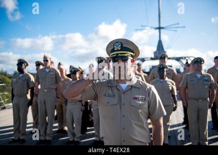 PEARL Harbor, Hawaii (Apr. 4, 2019) Kapitän Andrew Carlson, kommandierender Offizier der geführte Anti-raketen-Zerstörer USS Zumwalt (DDG 1000), begrüßt während der Morgen Farben an Bord der USS Missouri Memorial. Zumwalt leitet den Hafen besuchen Sie als Teil ihrer Routinetätigkeiten im östlichen Pazifik. Zumwalt Klasse Zerstörer bieten die Marine mit agilen militärische Vorteile im Meer und mit Bodentruppen an Land. Stockfoto