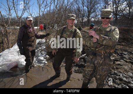 Army Staff Sgt. Jashua Trulson, rechts, und Sgt. Tyler Schlick, sowohl der 188 Ingenieur Unternehmen, Wahpeton, N.D., Hochwasser, wie sie sich vorbereiten, Sandsäcke, Wasser aus der Sicherung aus einer Drainage Düker in einem Bauernhof im ländlichen Cass County, in der Nähe von West Fargo, N.D., April 8, 2019. Sie sind Teil einer North Dakota Army National Guard Quick Response Force (Qrf) Team reagiert auf einen Notfall Sandsack Antrag der Hauseigentümer. Der Guard Quick Reaction Force (Qrf) hat 8 Missionen und weiterhin stehen an der Streitkräfte finden Zentrum am nördlichen Rand von Fargo wenn Addi Stockfoto