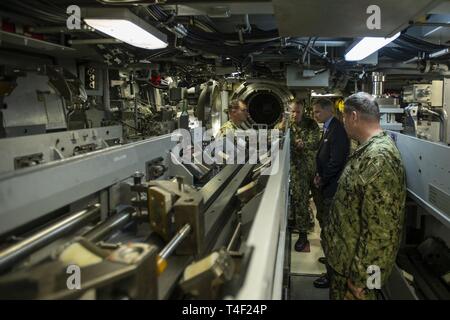 NORFOLK, Virginia (April 8, 2019) - Herr Gregory Slawischen, Assistant Secretary der Marine, diskutiert u-boot Flugkörperkapazitäten mit Kapitän Marty Mucklan, Commodore, Submarine Squadron Six und Cdr. Wird Willey, Kommandierender Offizier, USS John Warner (SSN785), während einer Tour an Bord der John Warner, 8. April 2019. Slawische ist zuständig für die Überwachung und Kontrolle von Arbeitskräften und finden allgemeine Angelegenheiten der Abteilung der Marine, einschließlich der Entwicklung der Programme und der Politik, die an Soldaten, deren Angehörige und die zivilen Mitarbeiter. Stockfoto