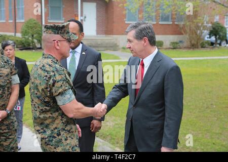 Roy Cooper, North Carolina Gouverneur schüttelt Hände mit Generalleutnant Robert F. Hedelund, Kommandierender General, II Marine Expeditionary Force auf MCIEAST-MCB Camp Lejeune in North Carolina, 9. April 2019. Dies ist Cooper's ersten Befehl Besuch MCB Camp Lejeune und WAB New River, der Gouverneur von North Carolina. Während seiner Tour, Cooper traf sich mit den Führungskräften beider Anlagen und sah aus erster Hand von den Schäden durch den Hurrikan Florenz links. Stockfoto