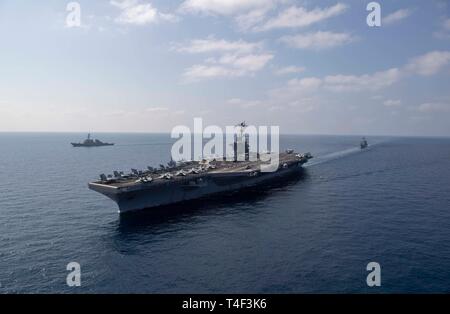 190411-N-YW 238-0387 Golf von Aden (4. April 2019) der Flugzeugträger USS John C Stennis (CVN 74), Mitte, die geführte Anti-raketen-Zerstörer USS McFaul (DDG74), links, und die Geführten-missile Cruiser USS Mobile Bay (CG53) Segeln in der Ausbildung in den Golf von Aden, 11. April 2019. Die John C Stennis Carrier Strike Group ist in die USA 5 Flotte Bereich der Maßnahmen zur Unterstützung der Marine im Einsatz für die Stabilität und Sicherheit in der Region zu gewährleisten und verbindet das Mittelmeer und den Pazifischen Raum durch den westlichen Indischen Ozean und drei strategischen Punkten ersticken. (U.S. Marine Foto von Masse Stockfoto