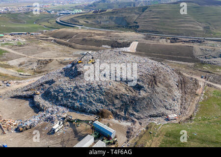 Antenne top drone Ansicht von großen Abfallhaufen, Müllkippe, Deponie, Abfälle aus Haushalt Dumping site, Bagger Maschine arbeitet auf einem Berg von Ga Stockfoto