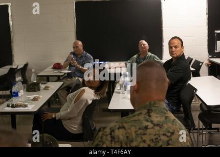 Us Marine Corps Chief Warrant Officer 2 Jeffrey Wright, Mitte, der verantwortliche Offizier der Pu'uloa Bereich Training Service, spricht mit Rep. Rida Arakawa, links, von Hawaii Ewa Bezirk und Mitchell Tynanes, rechts, Ewa Nachbarschaft Brett Stuhl, Marine Corps Base Hawaii (MCBH), 8.April 2019. Die Tour von Pu'uloa Bereich Training Service wurde auf Hawaii State Gesetzgeber Councilmember Ron Menor, councilmember Kymberly Kiefer, Sen. Kurt Fevella, Sen. Mike Gabbard, Rep. Rida Cabanilla Arakawa, Bob McDermott, und Ewa Beach Neighborhood-Vorsitzender Mitchell Tynanis zur Verfügung gestellt. Während der Begehung, MCB Stockfoto