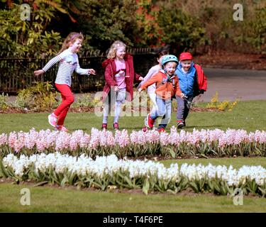 Glasgow, Schottland, Großbritannien. 11 Apr, 2019. UK Wetter: Sonnig Sommertag im Victoria Park als Grünfläche Blume der Stadt zeigt, wie Kinder spielen Stockfoto