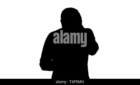 Silhouette betonte junger Mann überrascht, schockiert, entsetzt und gestört, durch das, was er sieht auf seinem Handy. Stockfoto