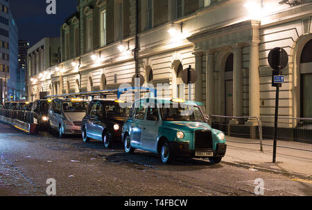 LONDON, Großbritannien - 25 November 2018: London Taxi, genannt Hackney Carriage, black cab auf dem Parkplatz an der Victoria Station. Night Shot Stockfoto