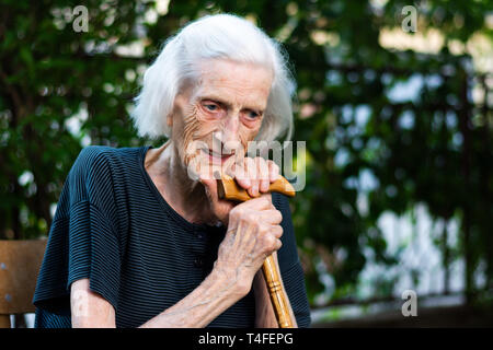 Porträt einer älteren Frau mit einem Spazierstock im Freien Stockfoto