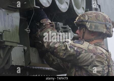 Ein Soldat mit Baker Batterie 3 Bataillon 321 Field Artillery Regiment von Fort Bragg, North Carolina, lädt eine High Mobility Artillery Rocket System (HIMARS), 9. April 2019. Die Soldaten waren die Teilnehmenden in Betrieb Gipfel schlagen, ein divison Ebene Übung zur Armee und Luftwaffe Partner und untergeordnete Manöver Einheiten ausbilden. Stockfoto