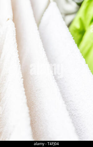 Weiße und farbige Bettwäsche und Handtücher auf der Wäscheleine getrocknet werden. Stockfoto