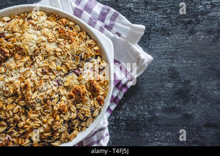 Müsli auf einem dunklen Hintergrund. Ansicht von oben, flach. Das Konzept der gesunden Sporternährung für Frühstück Stockfoto