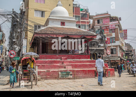 Eine Straße mit einem buddhistischen Tempel in der Innenstadt von Kathmandu, Nepal, am späten Nachmittag. Stockfoto