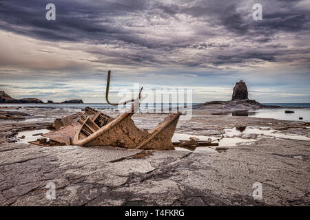 Das Wrack der Trawler "Admiral van Tromp' am Strand von Saltwick Bay, in der Nähe von Whitby, North Yorkshire, mit schwarzen Nab im Hintergrund. Stockfoto