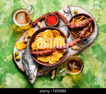 Auswahl an Bier und Snacks. Pommes, Fisch, Bier, Würstchen auf den Tisch Stockfoto