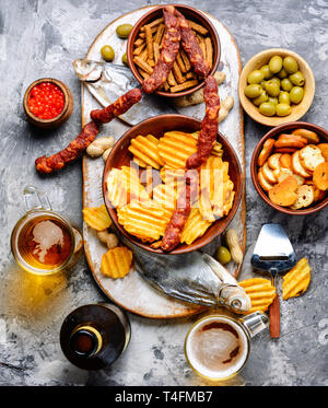 Auswahl an Bier und Snacks. Pommes, Fisch, Bier, Würstchen auf den Tisch Stockfoto