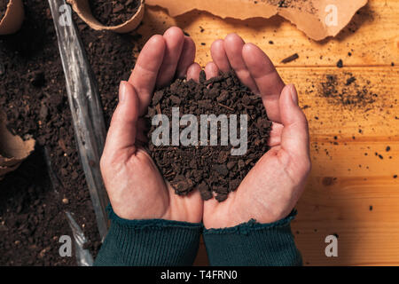 Gärtner holding Boden in hohlen Hände, Blick von oben auf die weiblichen Bio Lebensmittel Produzent Handvoll Humus für Pflanzen Stockfoto