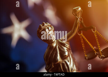 Recht und Gerechtigkeit in den Vereinigten Staaten von Amerika, Statue von Lady Gerechtigkeit mit USA-Flagge im Hintergrund, selektiver Fokus Stockfoto