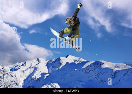 Snowboarder durch Luft mit blauen Himmel im Hintergrund springen Stockfoto