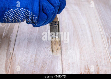 Mann malt eine weiße Lackoberfläche. Färbung Boards. Malerei Holzbretter. Stockfoto