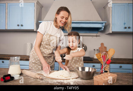 Glücklich liebende Familie bereitet Bäckerei zusammen. Mutter und Kind Tochter Mädchen machen Cookies und Spaß in der Küche. Mutter lehrt ihre Stockfoto