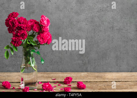 Rote Rosen Blumen Blumenstrauß in Vase mit Knospen herum. Womans Tag oder Hochzeit Hintergrund mit Kopie Raum Stockfoto