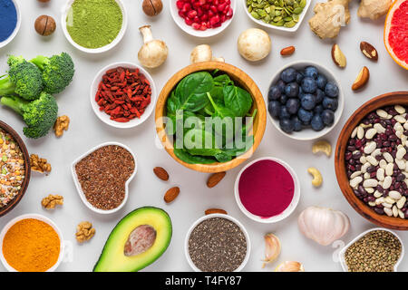 Verschiedene superfoods auf weißem Hintergrund. Gemüse, Matcha, Acai, Kurkuma, Früchte, Beeren, Avocado, Pilze, Nüsse und Samen gesund vegan f Stockfoto