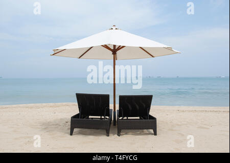 Zwei Liegen mit Sonnenschirm am Strand Jimbaran, Bali, Indonesien Stockfoto