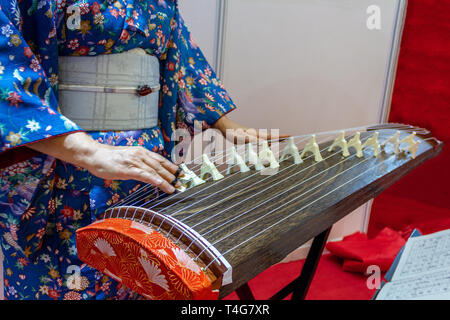 Frau im Kimono Kleid koto traditionelle japanische Instrument spielt. Stockfoto