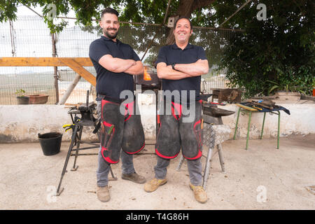 Schmiede team Arbeiten auf dem Amboss, wodurch ein Hufeisen. Stockfoto