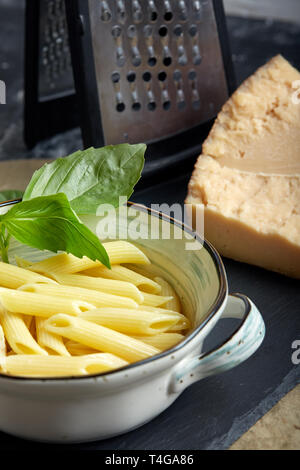 Pasta mit grüne Kräuter in Kupfer Kasserolle. Grauen Stein Hintergrund. Stockfoto