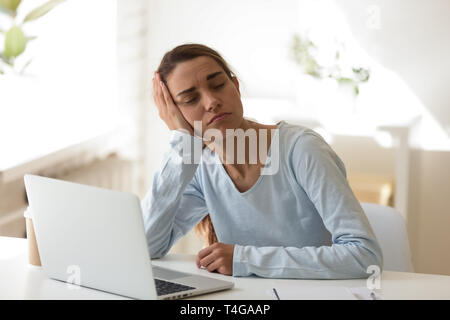 Müde Frau schlafen auf der Desktop in die Vorderseite des Computers Stockfoto