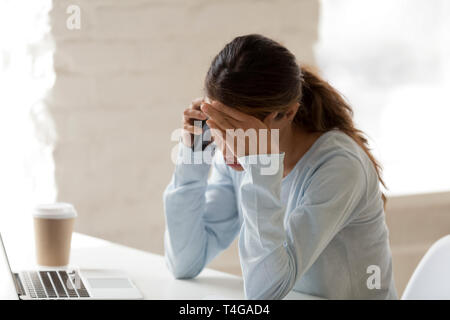 Betonte Frau bei der Arbeit Hand auf Ihre Stirn Stockfoto